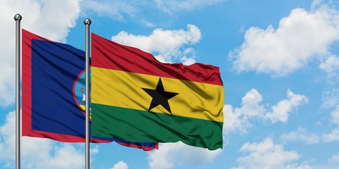 Guam and Ghana flag waving in the wind against white cloudy blue sky together. Diplomacy concept, international relations.