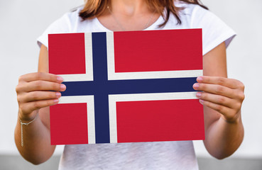 woman holds flag of Norway on paper sheet