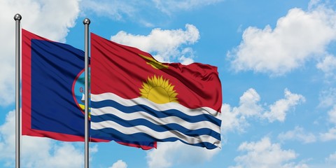 Guam and Kiribati flag waving in the wind against white cloudy blue sky together. Diplomacy concept, international relations.