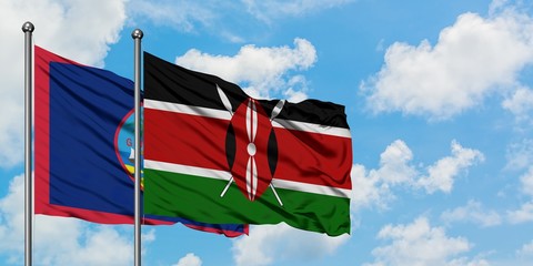 Guam and Kenya flag waving in the wind against white cloudy blue sky together. Diplomacy concept, international relations.