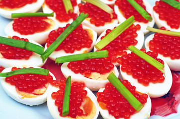 Boiled eggs with red caviar and green onions