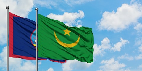 Guam and Mauritania flag waving in the wind against white cloudy blue sky together. Diplomacy concept, international relations.