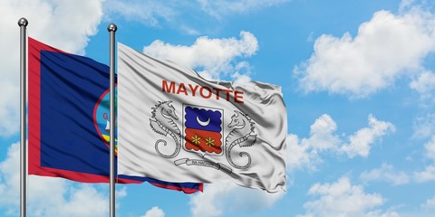Guam and Mayotte flag waving in the wind against white cloudy blue sky together. Diplomacy concept, international relations.