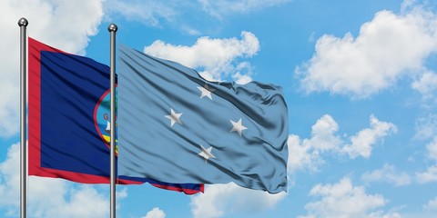 Guam and Micronesia flag waving in the wind against white cloudy blue sky together. Diplomacy concept, international relations.