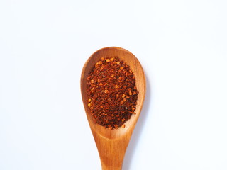 Red Chili powder in wooden spoon isolated on white background.