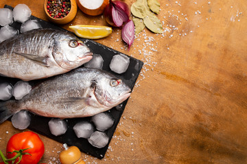 fresh fish on a cutting board with vegetables
