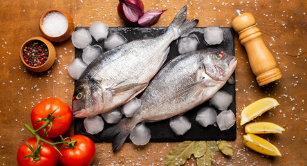 fresh fish on a cutting board with vegetables