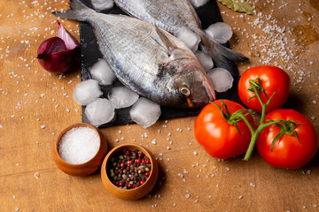 fresh fish on a cutting board with vegetables