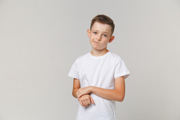 Portrait of upset boy standing with arms folded isolated over white background