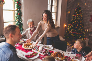 Placing food on the table for family Christmas dinner