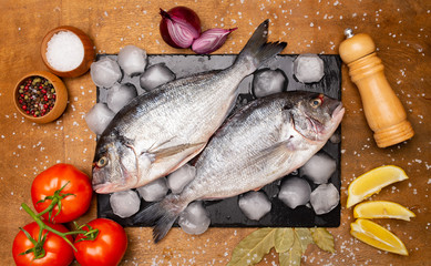 fresh fish on a cutting board with vegetables