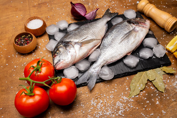 fresh fish on a cutting board with vegetables