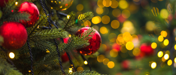 Winter Christmas holiday background - toys on a Christmas tree branch and blurry lights in the...