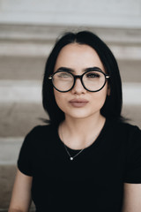 Portrait of Cute Brunette Girl in Black T-shirt in Glasses