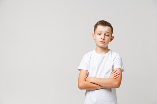 Sad young boy portrait on white background with copyspace
