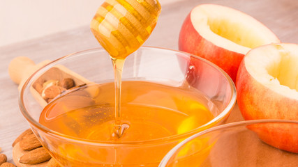 Cup with honey and apples for making baked apples with nuts and honey close-up