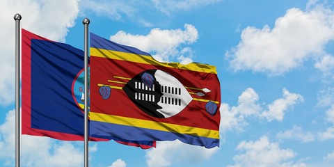 Guam and Swaziland flag waving in the wind against white cloudy blue sky together. Diplomacy concept, international relations.