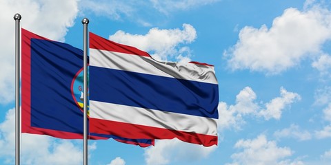 Guam and Thailand flag waving in the wind against white cloudy blue sky together. Diplomacy concept, international relations.