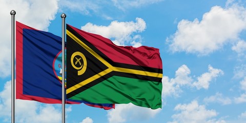 Guam and Vanuatu flag waving in the wind against white cloudy blue sky together. Diplomacy concept, international relations.