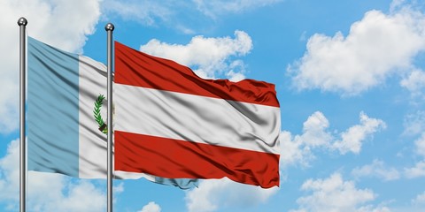 Guatemala and Austria flag waving in the wind against white cloudy blue sky together. Diplomacy concept, international relations.
