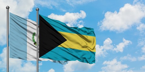 Guatemala and Bahamas flag waving in the wind against white cloudy blue sky together. Diplomacy concept, international relations.