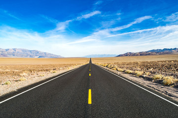 Fototapeta na wymiar Empty Straight Road in Arid Desert of the American Wild West - Death Valley National Park, California, USA