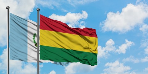 Guatemala and Bolivia flag waving in the wind against white cloudy blue sky together. Diplomacy concept, international relations.