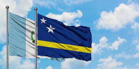 Guatemala and Curacao flag waving in the wind against white cloudy blue sky together. Diplomacy concept, international relations.