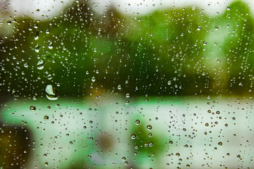 overlooking blur through the windshield of the car covered with rain for background