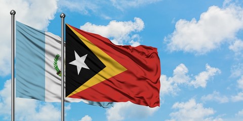 Guatemala and East Timor flag waving in the wind against white cloudy blue sky together. Diplomacy concept, international relations.
