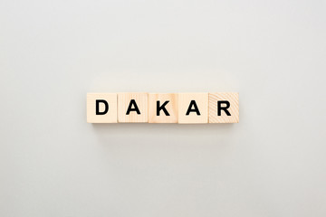 top view of wooden blocks with Dakar lettering on grey background