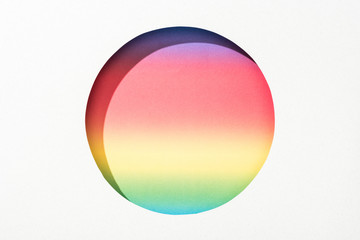 cut out round hole in white paper on colorful rainbow background