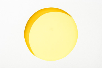 cut out round hole in white paper on colorful yellow background