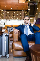 handsome businessman in suit and glasses talking on smartphone