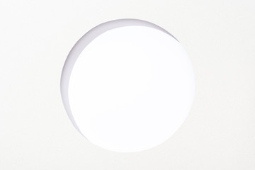 cut out round hole in white paper on white background - obrazy, fototapety, plakaty