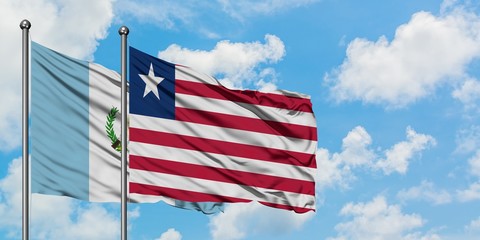 Guatemala and Liberia flag waving in the wind against white cloudy blue sky together. Diplomacy concept, international relations.