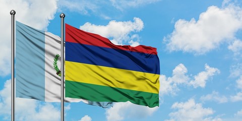 Guatemala and Mauritius flag waving in the wind against white cloudy blue sky together. Diplomacy concept, international relations.