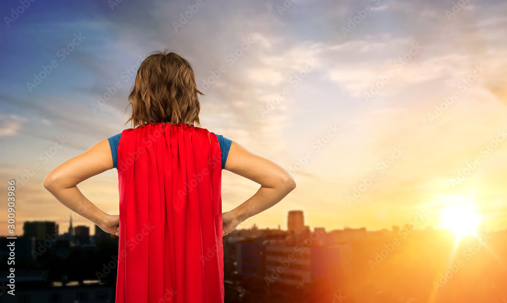 Wall mural women's power and people concept - back view of young woman in red superhero cape over sunset in tal