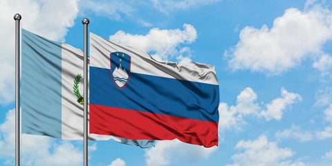 Guatemala and Slovenia flag waving in the wind against white cloudy blue sky together. Diplomacy concept, international relations.
