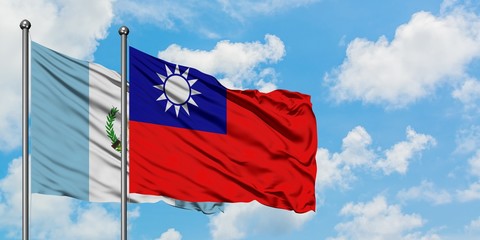 Guatemala and Taiwan flag waving in the wind against white cloudy blue sky together. Diplomacy concept, international relations.