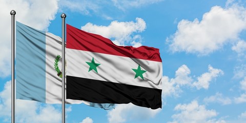 Guatemala and Syria flag waving in the wind against white cloudy blue sky together. Diplomacy...