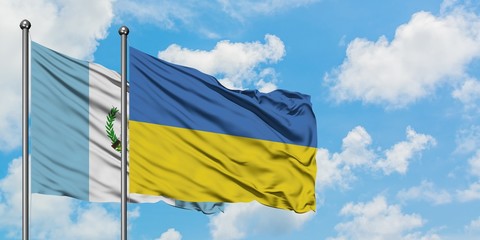 Guatemala and Ukraine flag waving in the wind against white cloudy blue sky together. Diplomacy concept, international relations.