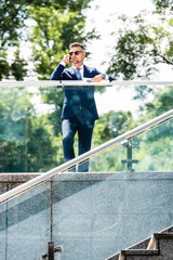 handsome businessman in suit and glasses talking on smartphone