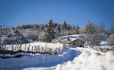Panoramic view of beautiful mountain landscape with wooden house / shack surrounded with snow
