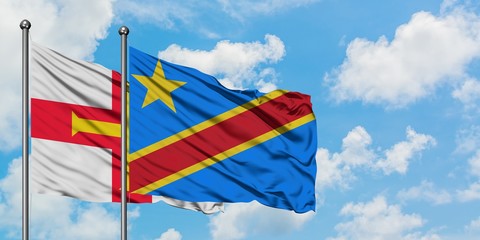 Guernsey and Congo flag waving in the wind against white cloudy blue sky together. Diplomacy concept, international relations.