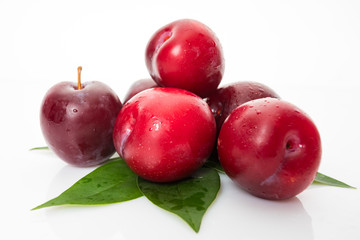 plums with plum leaves on a white background
