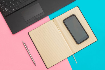 Flat lay of workspace with laptop, notebook, smartphone and pen