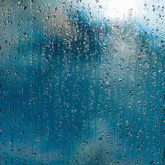 heavy rain drops on blue window