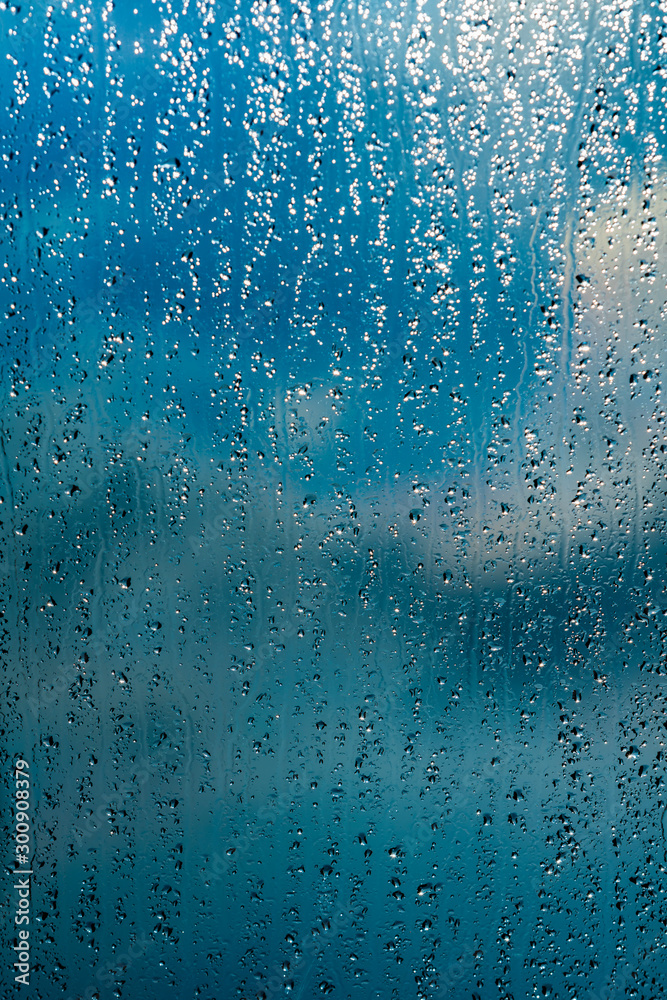 Wall mural rain drops on window blue background