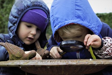 children looking into magnifying glass